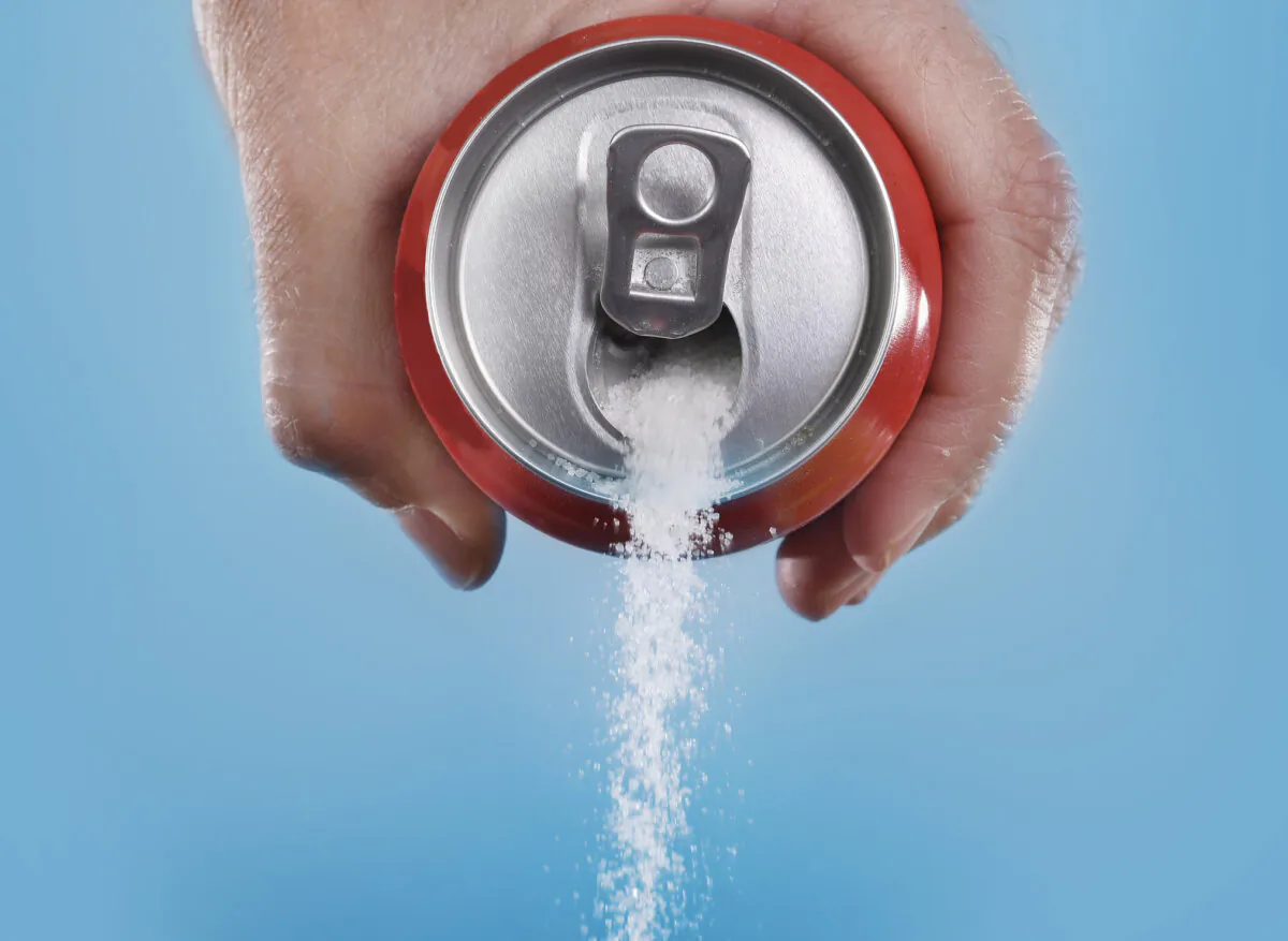 A hand holding a soda can pouring a crazy amount of sugar in metaphor of sugar content. (Getty Images)