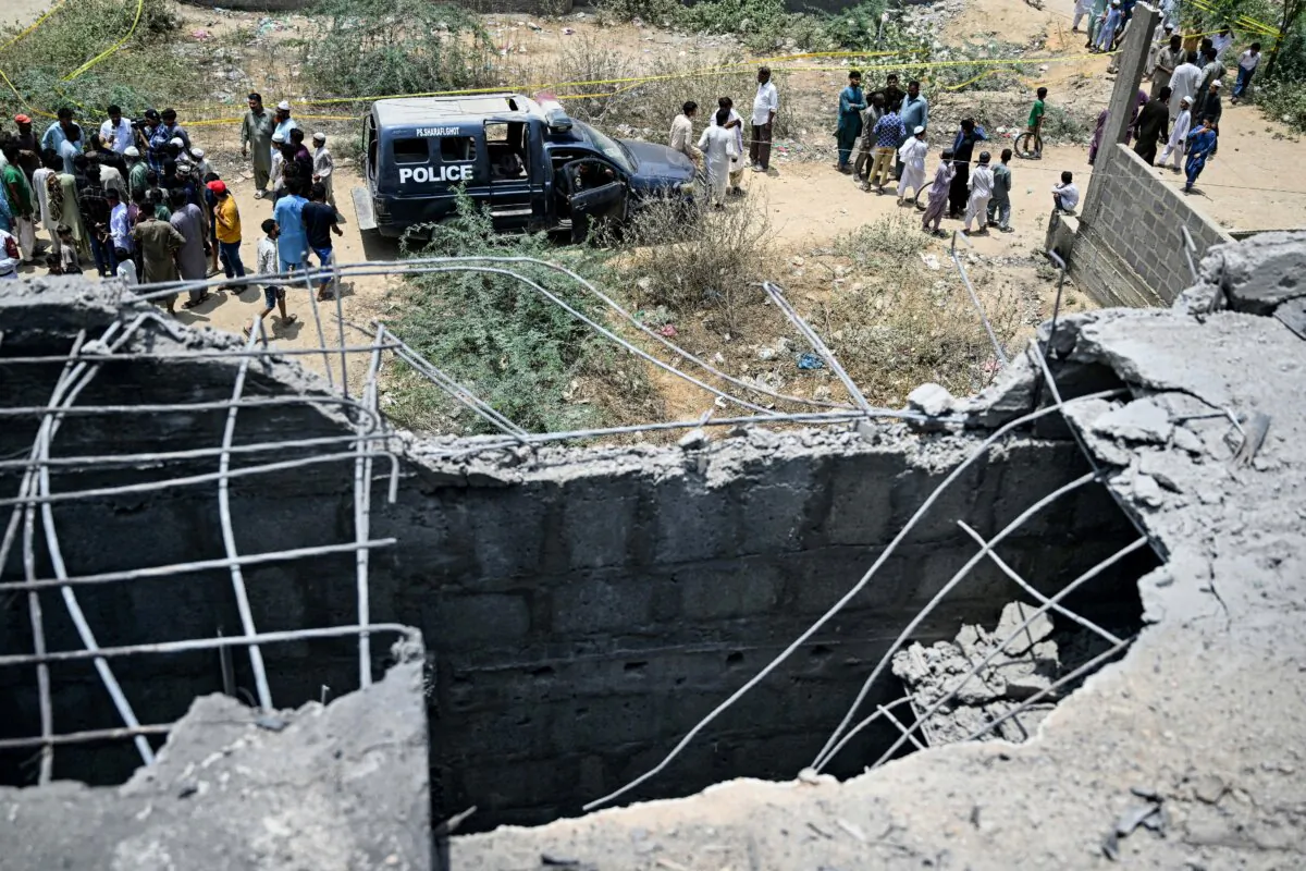 Residents gather as police personnel inspect the site where an alleged drone was shot down in Karachi on May 8, 2025. (Rizwan Tabassum/AFP via Getty Images)