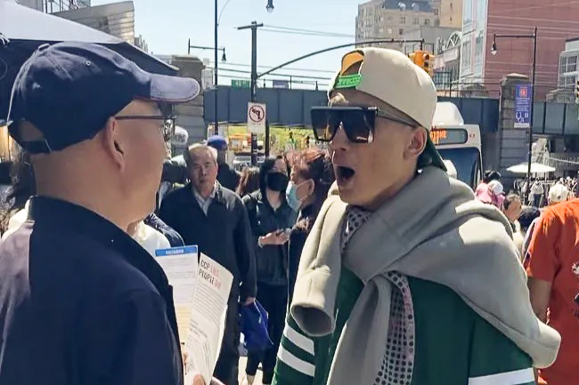 A Chinese man who identified himself as Fan Yang (R) verbally accosts volunteers at a Global Service Center for Quitting the CCP booth in the Flushing neighborhood of Queens, N.Y., on April 29, 2025. 
(Courtesy of Global Service Center for Quitting the CCP)