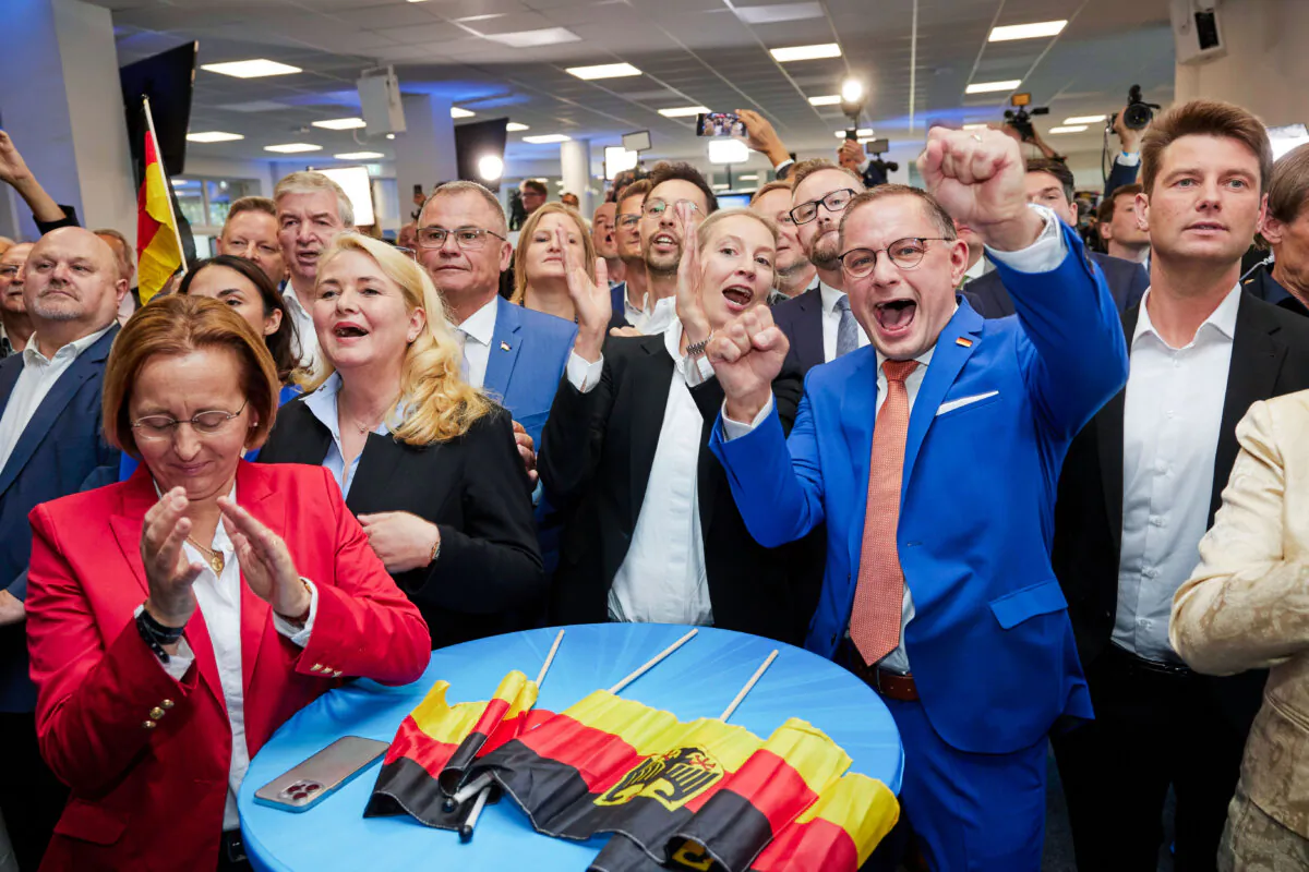 Alice Weidel, center, and Tino Chrupalla, center rught, both AfD federal chairmen, cheer at the AfD party headquarters during the forecast for the European elections, in Berlin, Sunday June 9, 2024. (Joerg Carstensen/dpa via AP)
