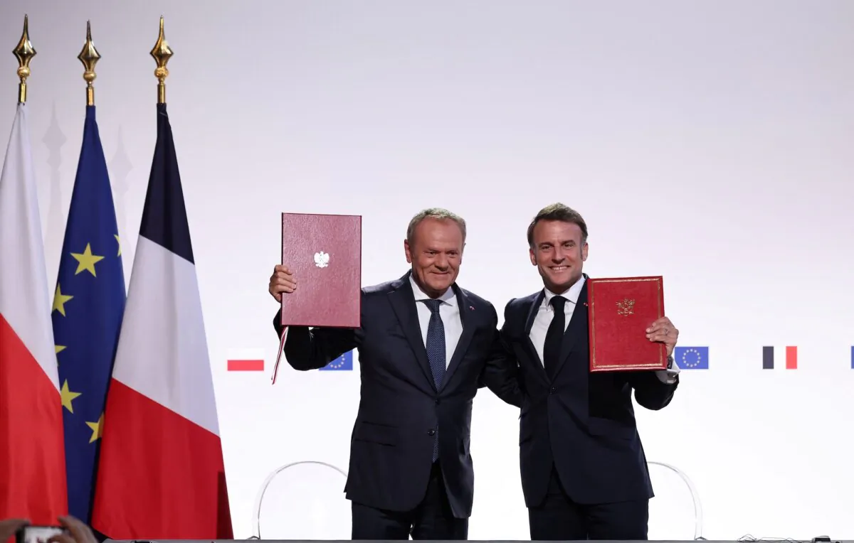 French President Emmanuel Macron and his then-Polish counterpart Donald Tusk sign a Friendship and Strategy Treaty in Nancy, France, on May 9, 2025. (Christophe Petit Tesson/Pool via Reuters)