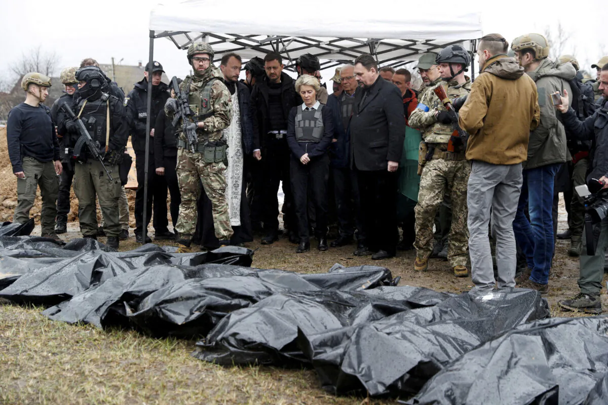 European Commission President Ursula von der Leyen (C) with other European dignitaries next to body bags as they visit the town of Bucha, outside of Kyiv, Ukraine, on April 8, 2022. (Valentyn Ogirenko/Reuters)