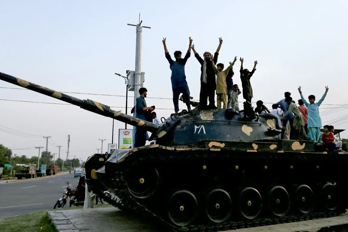 Pakistani people flash victory signs as they celebrate after the ceasefire between Pakistan and India, in Multan, on May 10, 2025. (Shahid Saeed Mirza/AFP via Getty Images)          