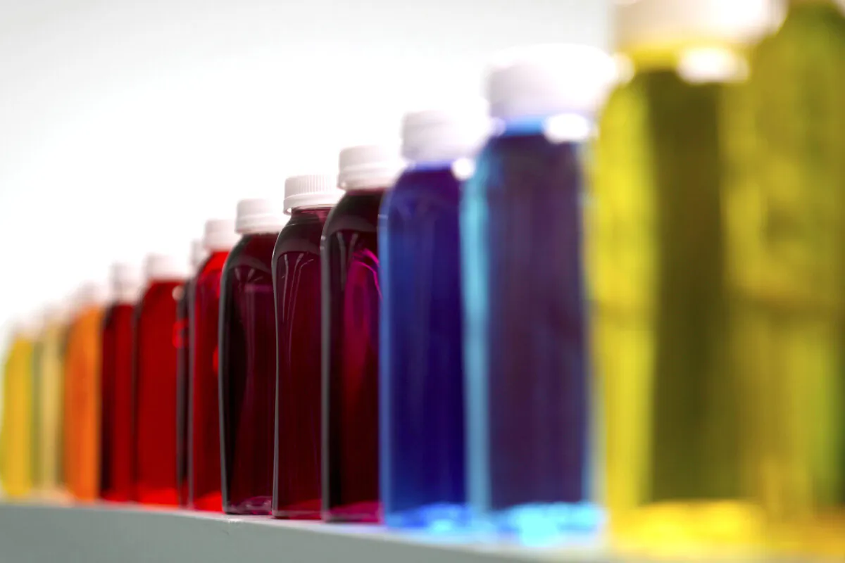 Bottles containing a variety of colored liquids sit on a shelf in a lab at Sensient Technologies Corp., a color additive manufacturing company, in St. Louis., on April 2, 2025. (Jeff Roberson/AP Photo)