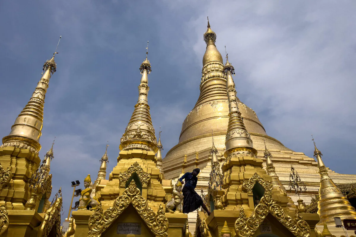 A man cleans and paints a statue at the Shwedagon Pagoda in Yangon, Burma, on May 11, 2025. (Sai Aung Main/AFP via Getty Images)