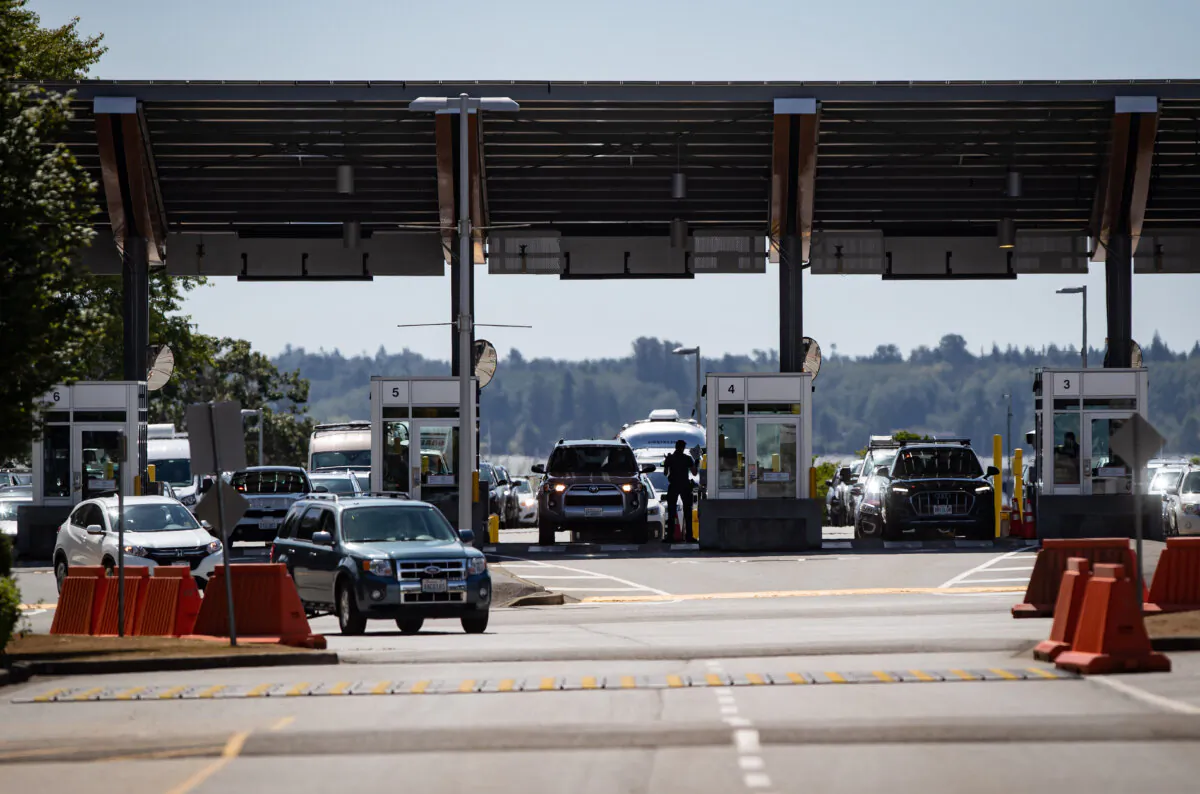 A Canada Border Services Agency officer is silhouetted as motorists enter Canada at the Douglas-Peace Arch border crossing, in Surrey, B.C., on Aug. 9, 2021. (The Canadian Press/Darryl Dyck)