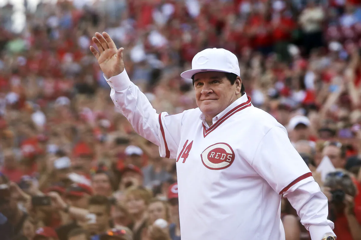 Former Cincinnati Red Pete Rose waves to the crowd as he is introduced on the field during a ceremony to honor the 1976 World Series champions team, before the Reds' baseball game against the San Diego Padres in Cincinnati, Ohio, on June 24, 2016. (John Minchillo/AP Photo)
