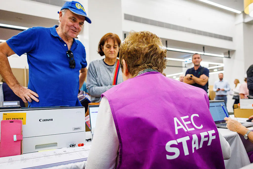 Voters receive there ballots from Australian Electoral Commission staff at a pre-polling centre inside the Brisbane City Hall in Brisbane on May 2, 2025. (PATRICK HAMILTON/AFP via Getty Images)