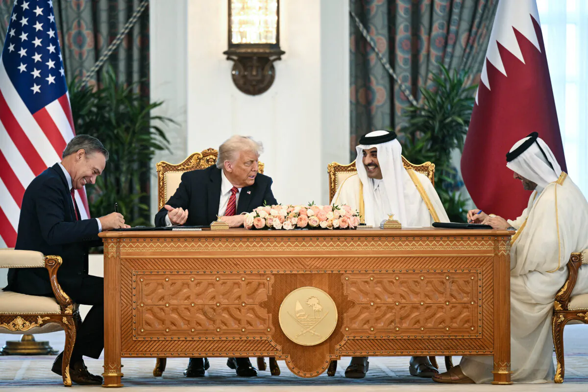 Boeing CEO Kelly Ortberg sits to the left of President Donald Trump and Qatar's Emir Sheikh Tamim bin Hamad al-Thani (R) during a business deal signing ceremony at the Royal Palace in Doha, Qatar, on May 14, 2025. (Brendan Smialowski/AFP via Getty Images)