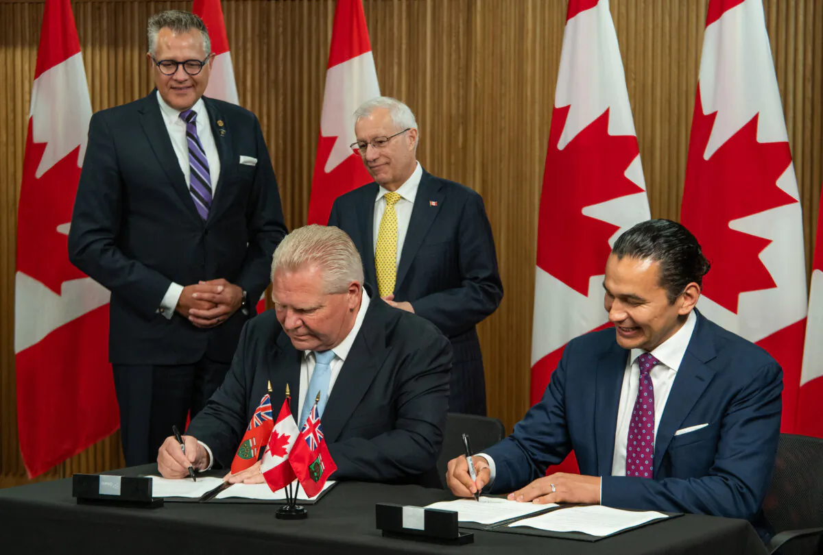 Ontario Premier Doug Ford, left, and Manitoba Premier Wab Kinew sign a Memorandum of Understanding at Queen’s Park in Toronto on May 14, 2025. (THE CANADIAN PRESS/Laura Proctor)