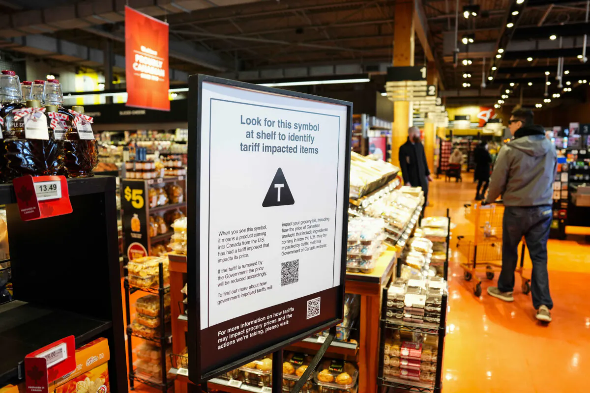 A sign in a grocery store advises that U.S. products affected by a tariff will be marked with a symbol and with a QR code provided that links to a Canadian government website, in Ottawa on April 2, 2025. (The Canadian Press/Justin Tang)
