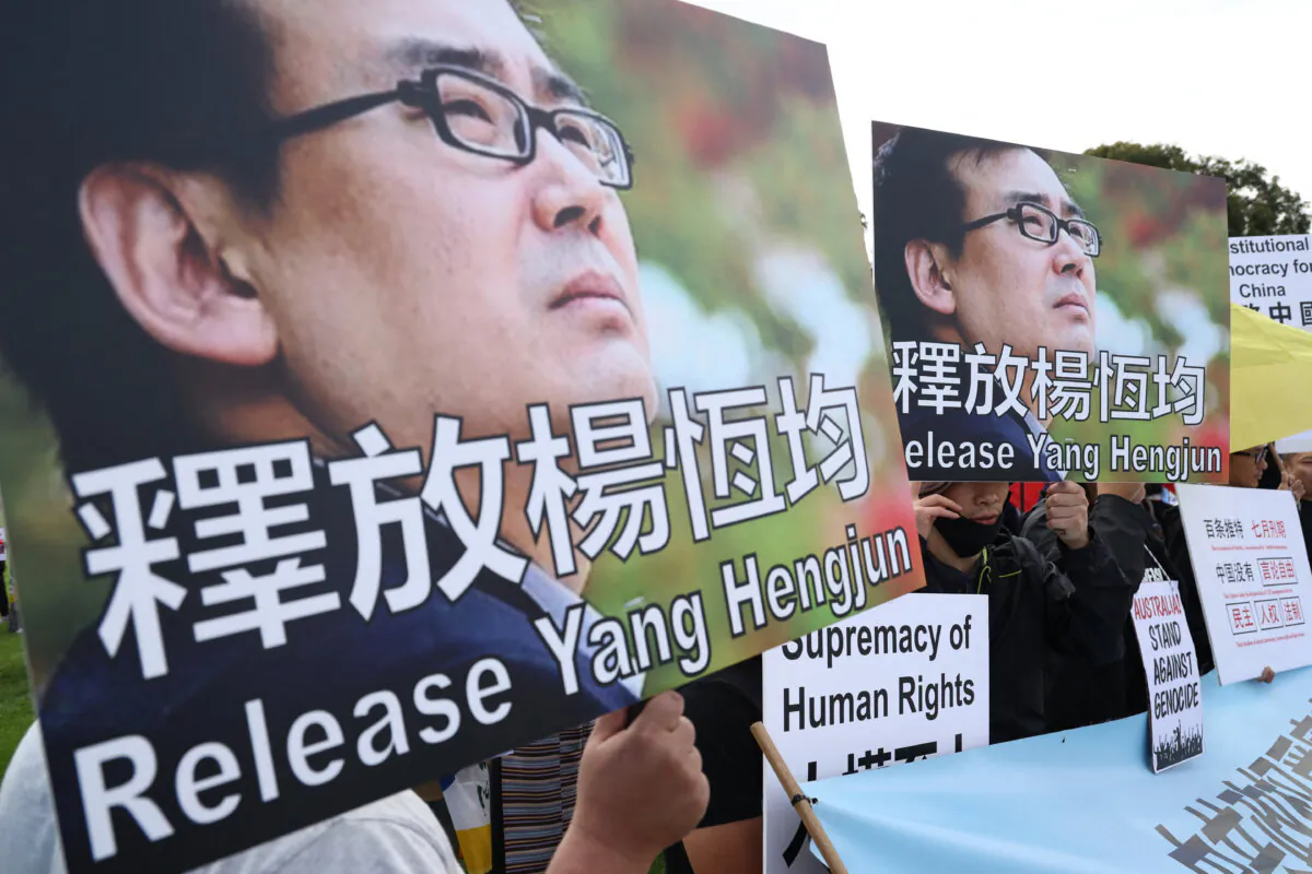 Protesters hold placards demanding the release of Australian writer Yang Hengjun in Canberra, Australia, on March 20, 2024. (David Gray/AFP via Getty Images)