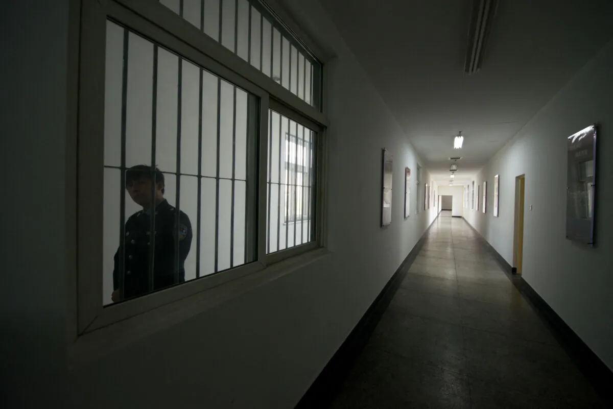 A guard looks through the window of a hallway inside a detention center in Beijing, on Oct. 25, 2012. (Ed Jones/AFP via Getty Images)