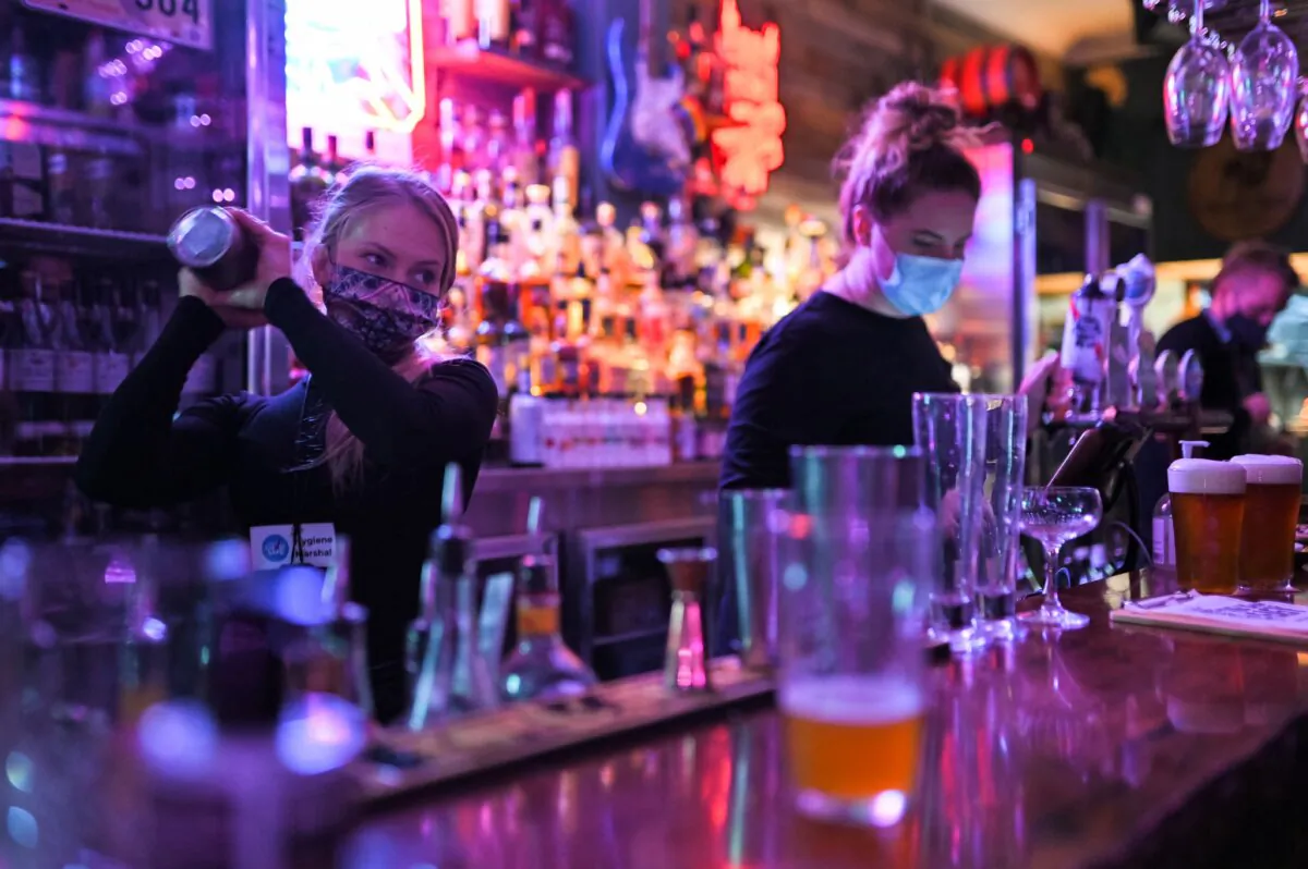 Bartenders work inside a bar in Sydney, Australia, on Oct. 11, 2021.(Steven Saphore/AFP via Getty Images)