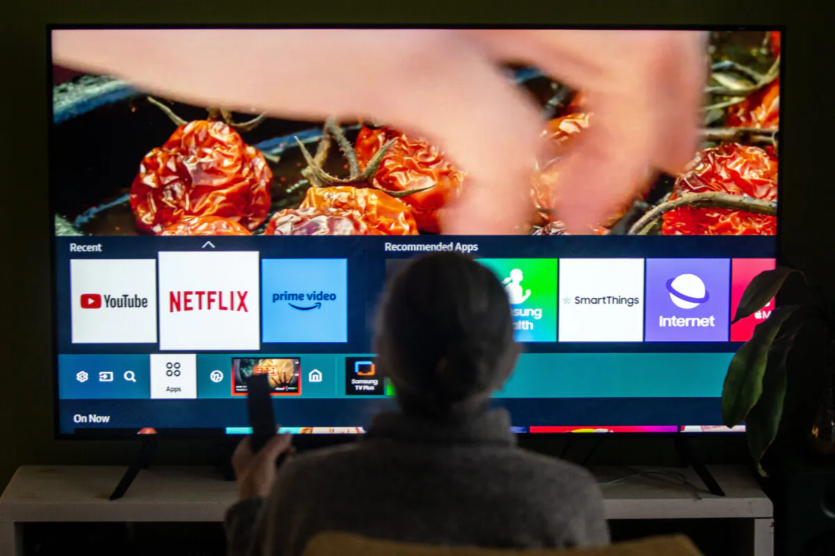 A person browses a television menu showing icons for streaming services Netflix and Amazon Prime in a photo illustration made in Toronto on March 22, 2024. (The Canadian Press/Giordano Ciampini)