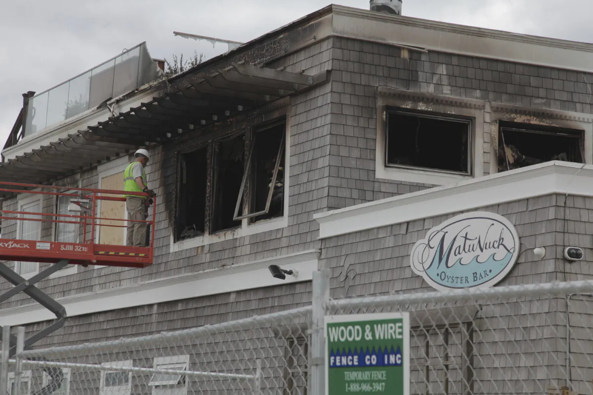 Crews work on boarding up broken windows after a fire damaged Matunuck Oyster Bar in South Kingston, R.I., on May 20, 2025. (Kimberlee Kruesi/AP Photo)
