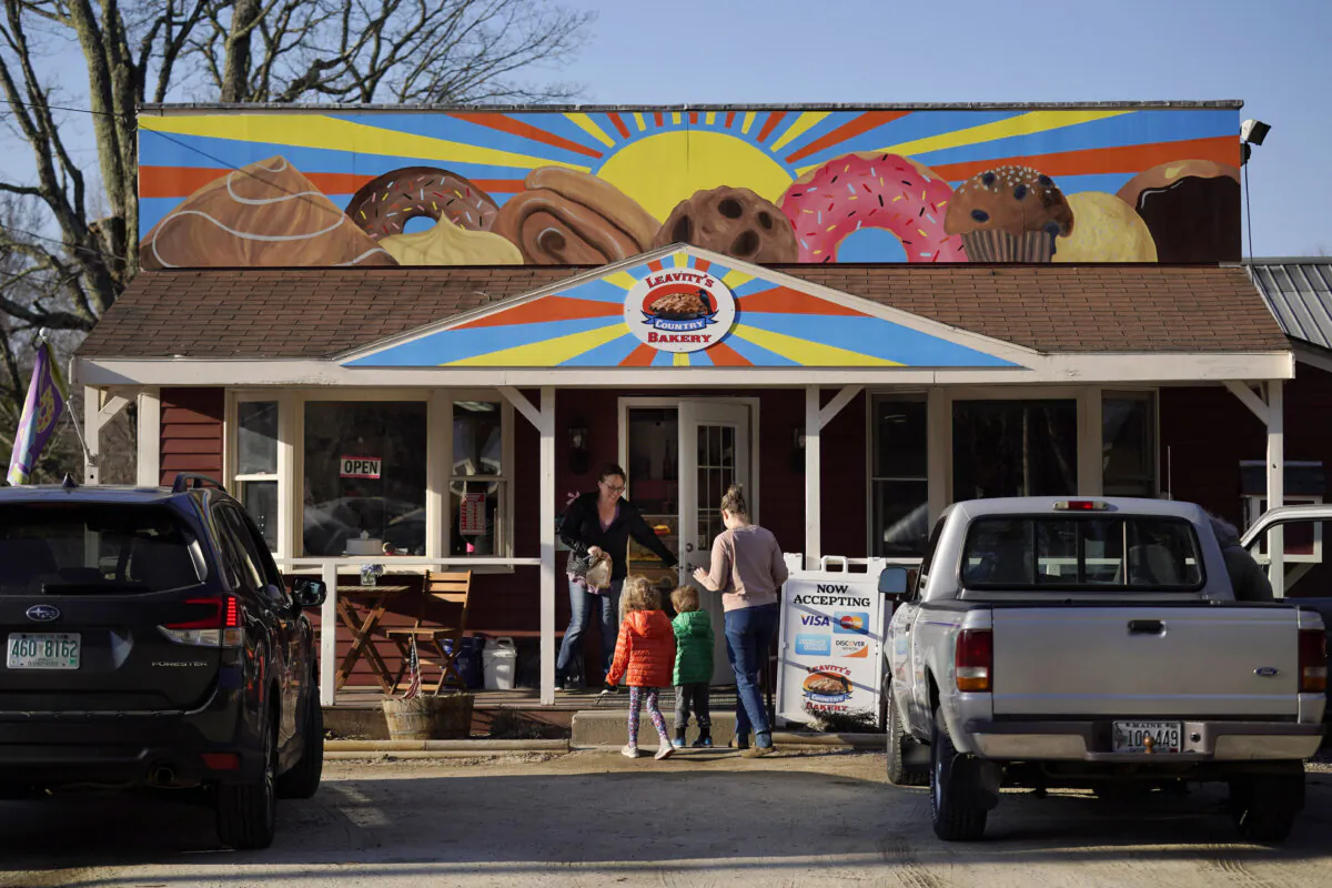 A customer holds the door for a family arriving at Leavitt's Country Bakery in Conway, N.H, on April 13, 2023. (Robert F. Bukaty/AP Photo)