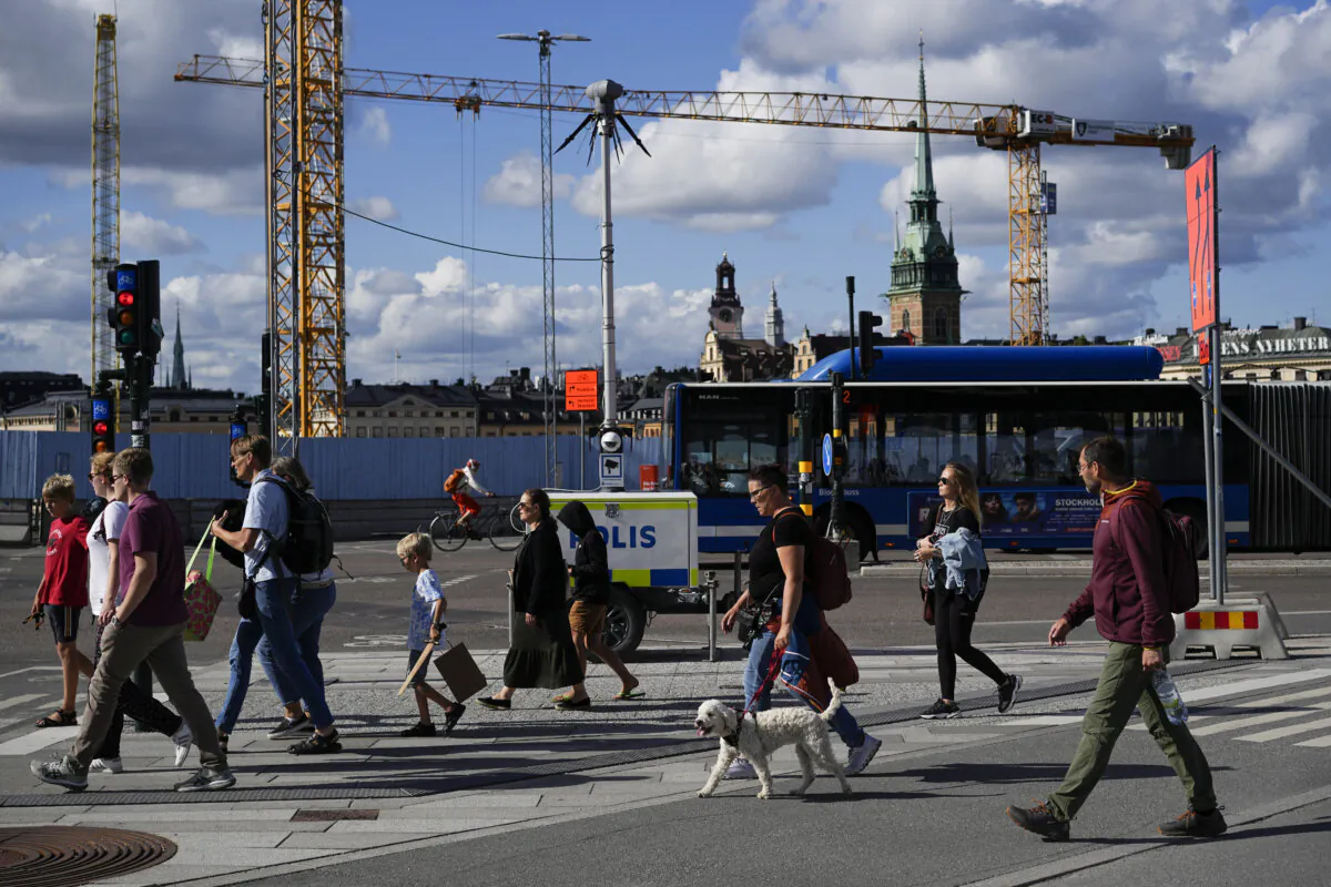 People cross a street in Stockholm, Sweden, on July 27, 2023. (AP Photo/Pavel Golovkin)