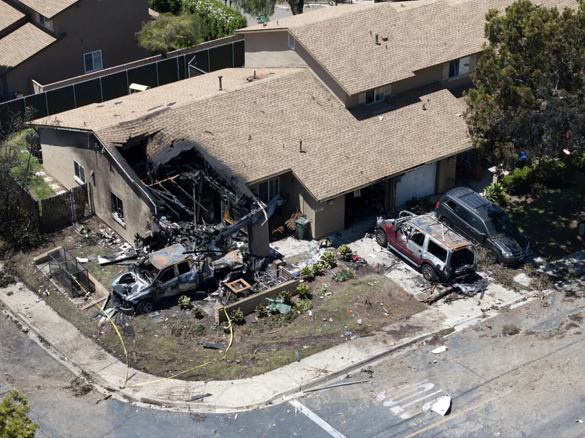 Debris covers the ground after a small plane crashed into a San Diego neighborhood, setting homes and cars on fire and forcing evacuations on May 22, 2025. (William Liang/AP Photo)