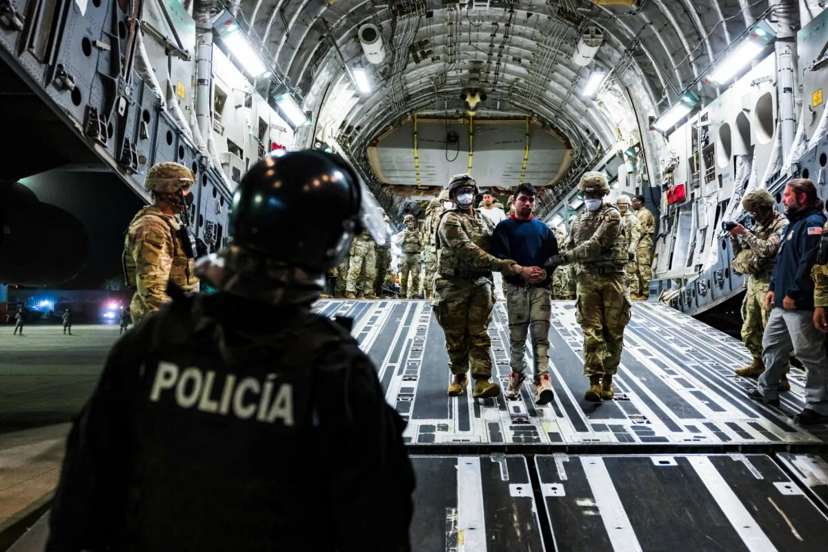 U.S. military personnel escort alleged members of the Venezuelan gang Tren de Aragua and the MS-13 gang recently deported by the U.S. government to be imprisoned in the Terrorism Confinement Center prison at the El Salvador International Airport in San Luis Talpa, El Salvador, on April 12, 2025. (Secretaria de Prensa de la Presidencia/Handout via Reuters)