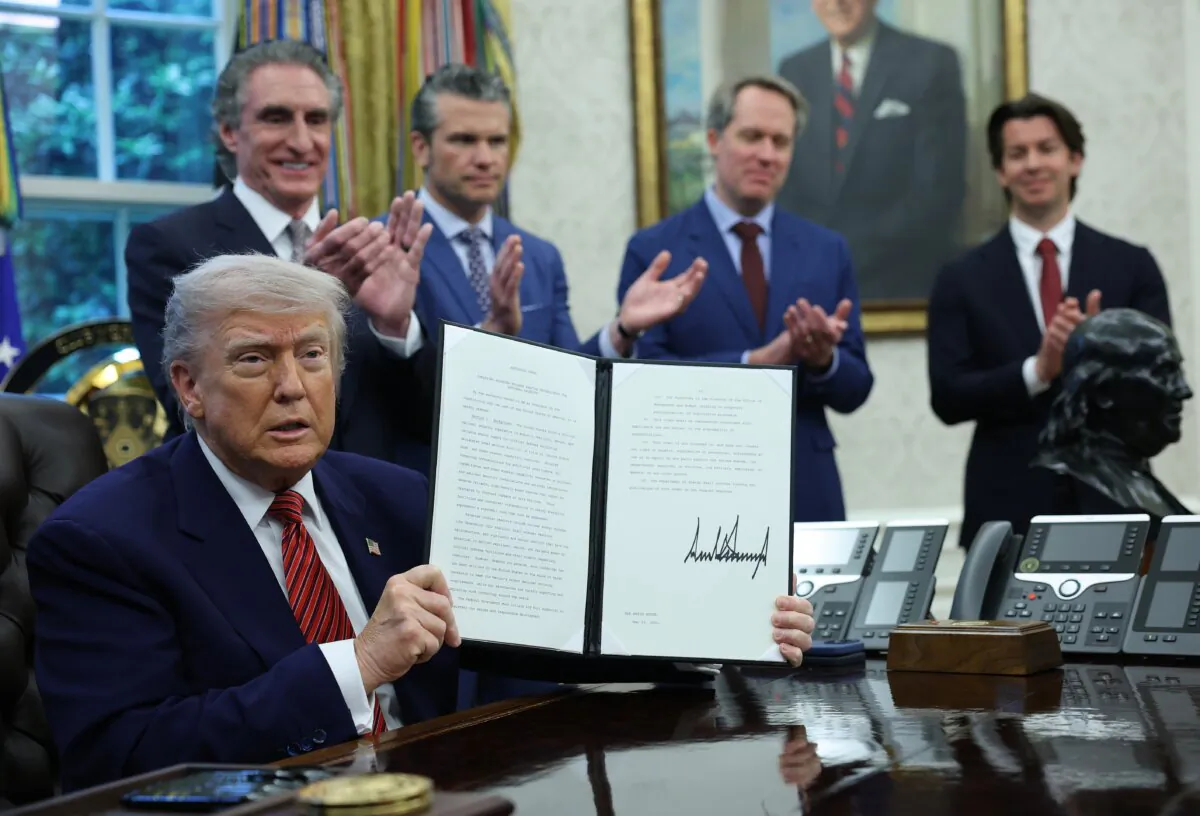 President Donald Trump holds up a signed executive order related to the nuclear power industry in the Oval Office on May 23, 2025. (Win McNamee/Getty Images)