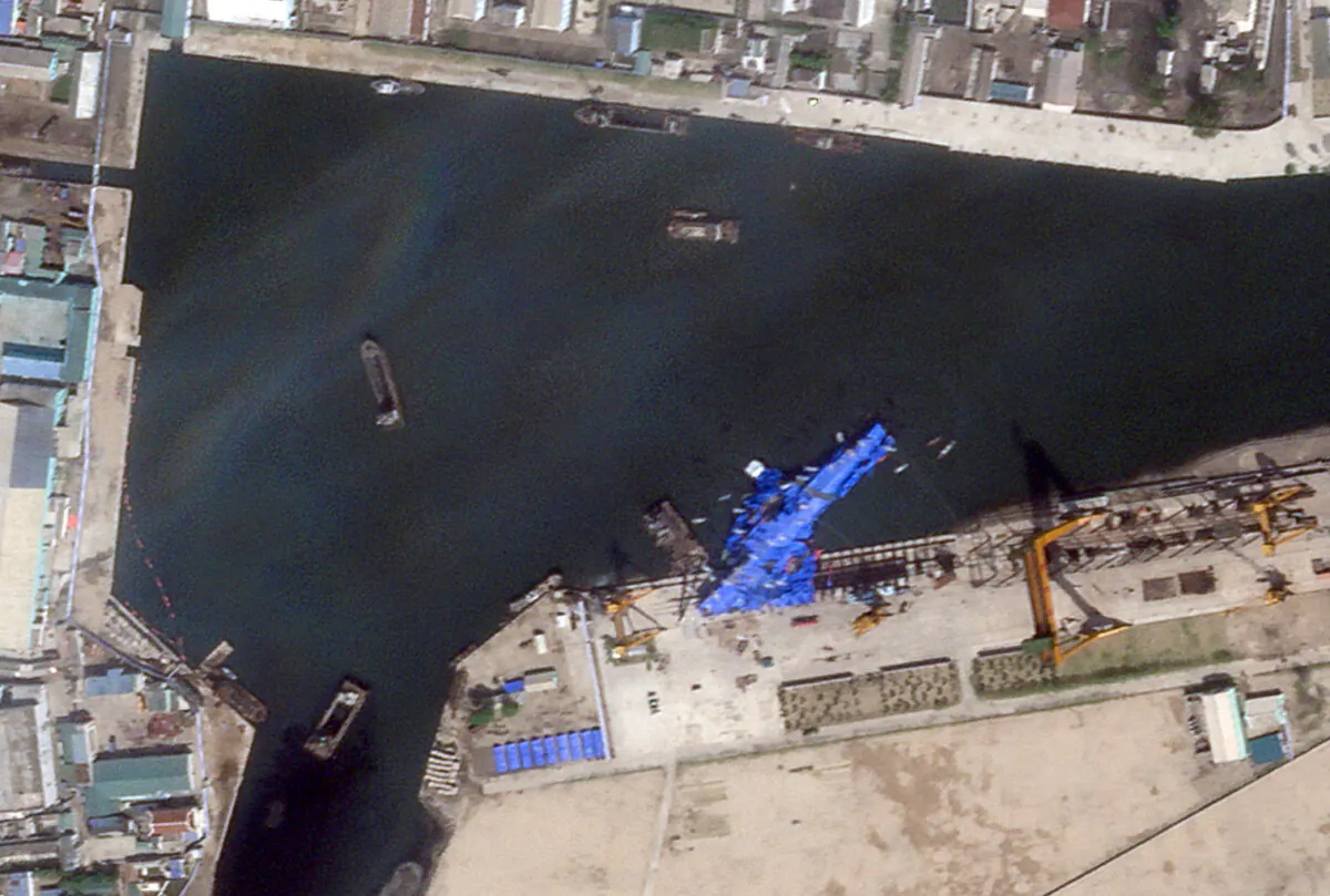 A satellite image shows a North Korean warship covered with a blue tarp after an accident that occurred during its launch at the shipyard in Chongjin, North Korea, on May 23, 2025. (Planet Labs PBC/Handout via Reuters)