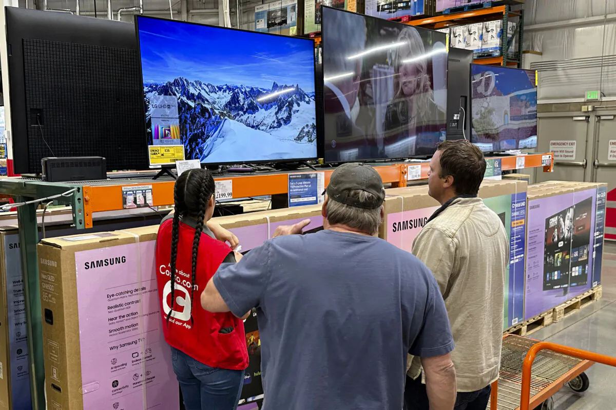 Shoppers consider a large-screen television with the help of a sales associate in a Costco warehouse in Sheridan, Colo., on May 1, 2025. (David Zalubowski/AP Photo)