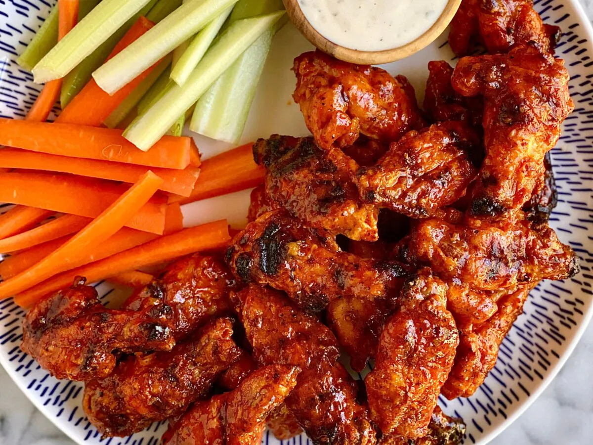 Cornstarch makes these grilled wings crispy before they’re tossed in classic Buffalo wing sauce. (Kelli Foster/TCA) 