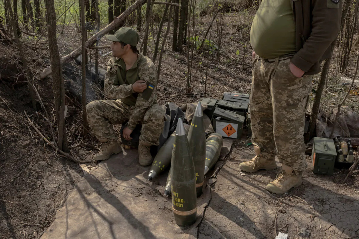 Ukrainian servicemen of the Skala regiment artillery unit wait next to shells as their fellow soldiers fire an M109 howitzer toward Russian positions, in an undisclosed area, in the eastern Donetsk region, on April 23, 2025. (Roman Pilipey/ AFP via Getty Images)