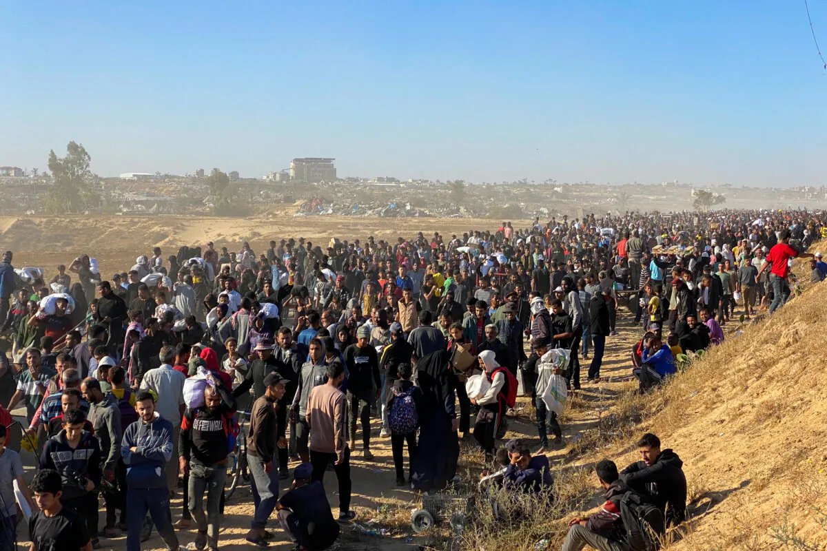 People carrying bags of relief supplies return from aid distribution centers in Rafah, Gaza Strip, to their tents in the southern Gaza Strip on May 29, 2025. (AFP)