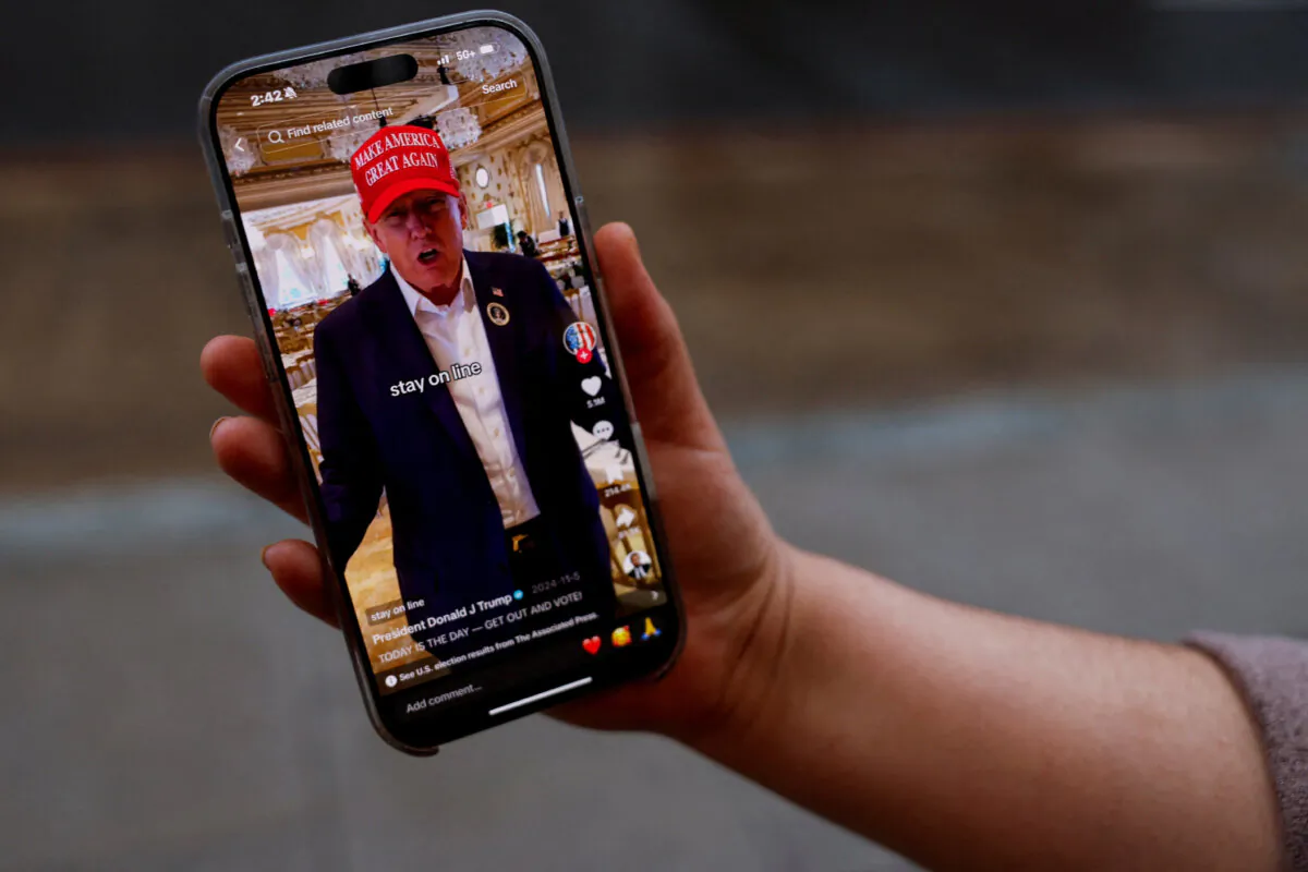 A woman poses with her smartphone displaying the @realdonaldtrump TikTok page, in Washington on Jan.19, 2025. (Shannon Stapleton/Reuters)