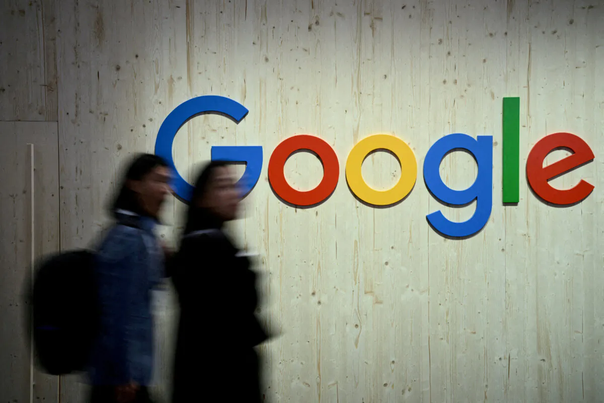 People walk next to a Google logo during a trade fair in Hannover Messe, in Hanover, Germany, on April 22, 2024. (Annegret Hilse/Reuters)