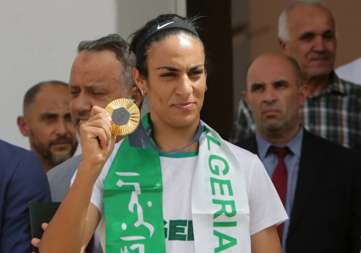 Imane Khelif shows the Olympic gold medal for women's boxing at the airport in Algiers, Algeria on Aug. 12, 2024. (Ramzi Boudina/Reuters)