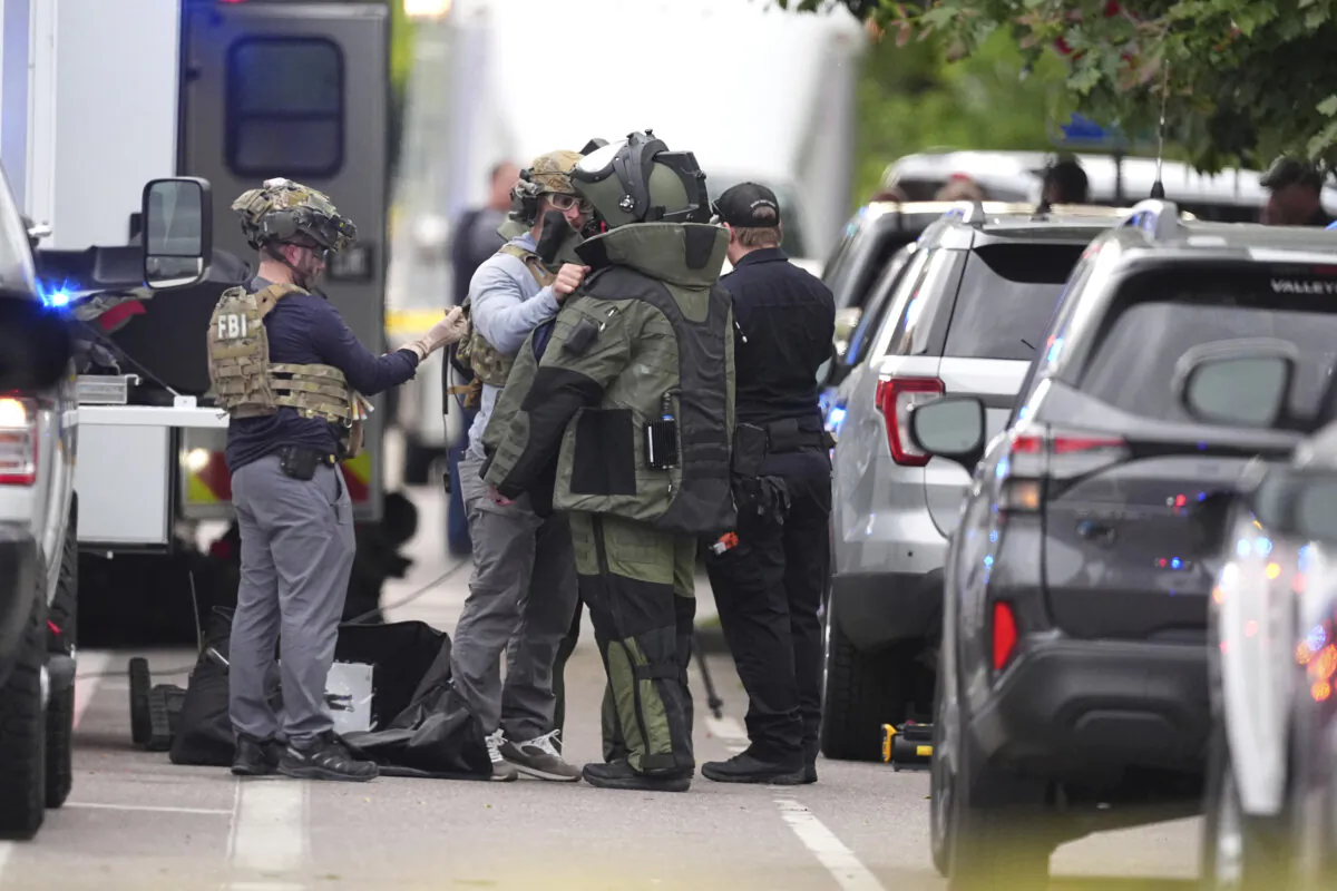 Law enforcement officials dress up in protective gear to investigative an attack on the Pearl Street Mall in Boulder, Colo., on June 1, 2025. (David Zalubowski/AP Photo)