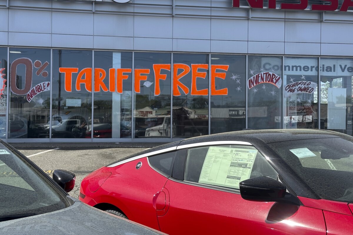 A sign referencing tariffs is visible at a car dealership in Totowa, N.J., on April 30, 2025. (AP Photo/Ted Shaffrey)