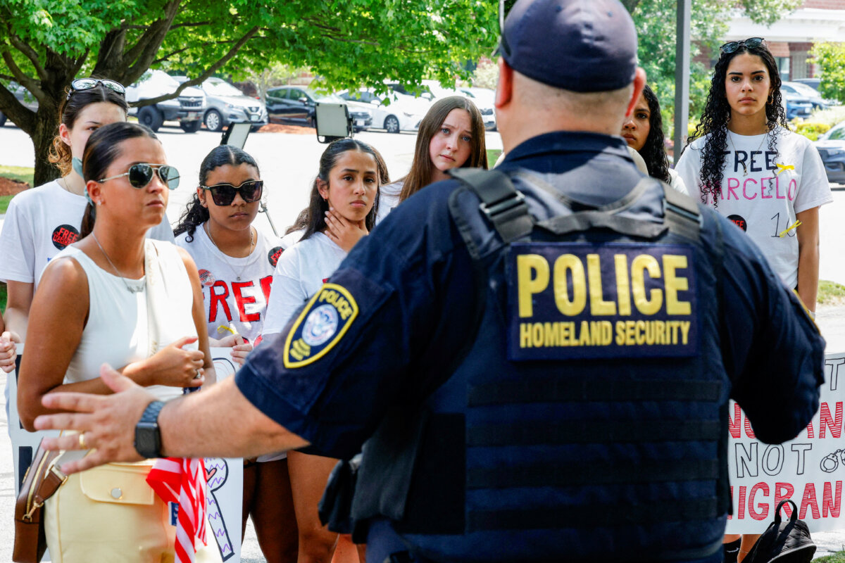 A Homeland Security officer speaks to classmates and relatives gathered outside immigration court in Chelmsford, Mass., on June 5, 2025. (Brian Snyder/Reuters)