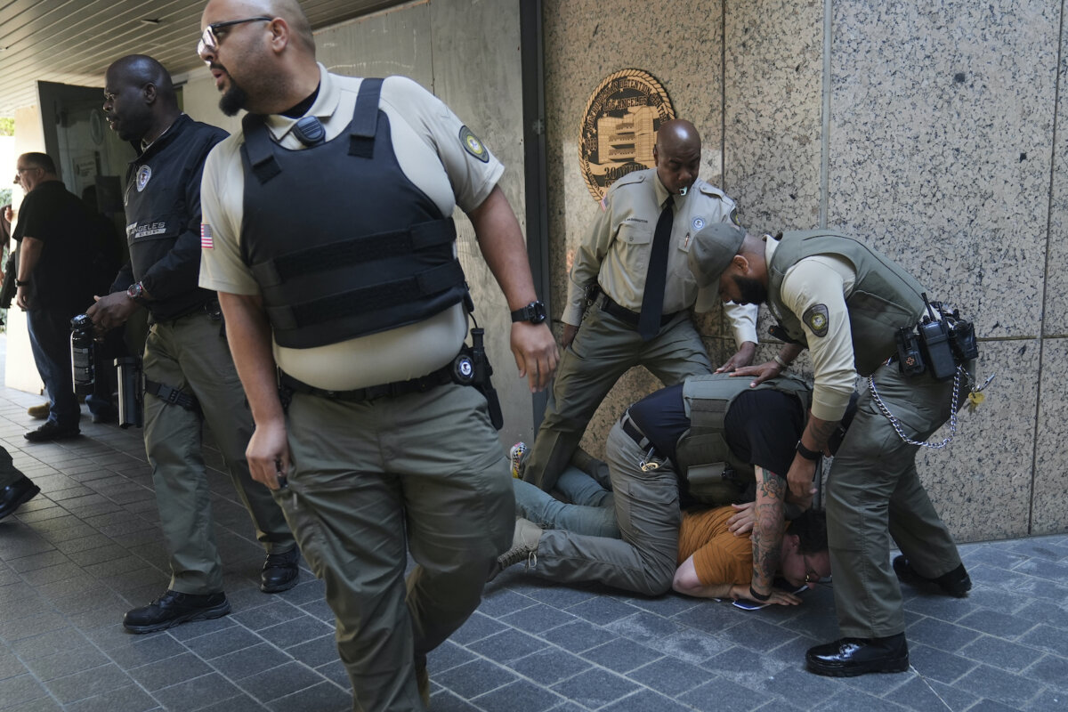 Law enforcement detain a protester at the U.S. Department of Justice Federal Bureau of Prisons after federal immigration authorities conducted an operation in Los Angeles on June 6, 2025. (Jae C. Hong/AP Photo)