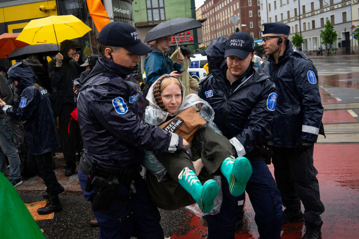 A climate activist is detained by police after blocking a road during a protest in Helsinki on June 9, 2025. (Tiago Mazza/Hans Lucas/AFP/Getty Images)