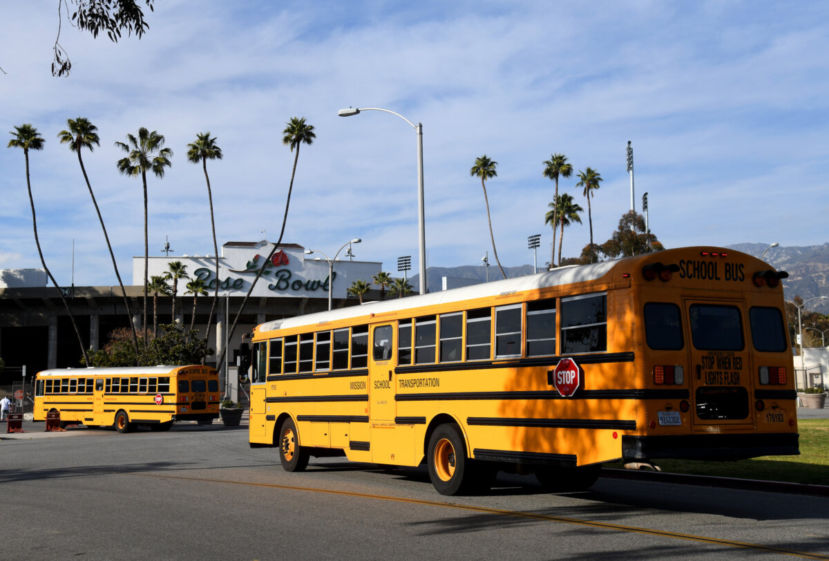 School buses bring in players from the Burbank Bulldogs and the Pasadena Bulldogs before their game at Rose Bowl in Pasadena, Calif., on March 19, 2021. (Harry How/Getty Images)