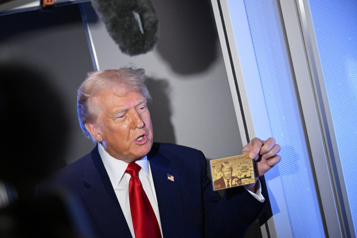 President Donald Trump holds the $5 million "gold card" while in flight aboard Air Force One on April 3, 2025. (Photo by MANDEL NGAN/AFP via Getty Images)