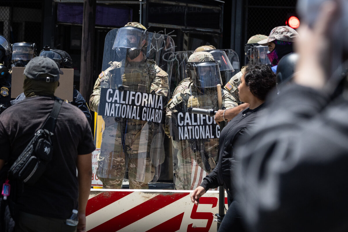 Immigration protesters confront federal agents and California Army National Guard members in Los Angeles on June 8, 2025. (John Fredricks/The Epoch Times)