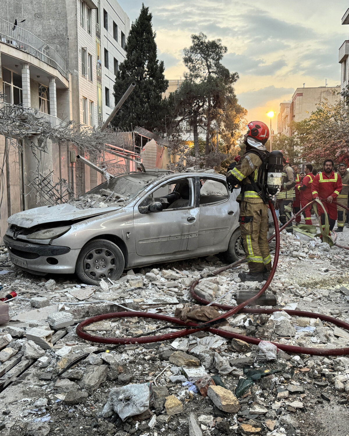 First-responders gather outside a building that was hit by an Israeli strike in Tehran, Iran, on June 13, 2025. Israel hit about 100 targets in Iran on June 13, including nuclear facilities and military command centres and killing senior figures including the armed forces chief and top nuclear scientists. (Meghdad Madadi/TASNIM NEWS/AFP via Getty Images)