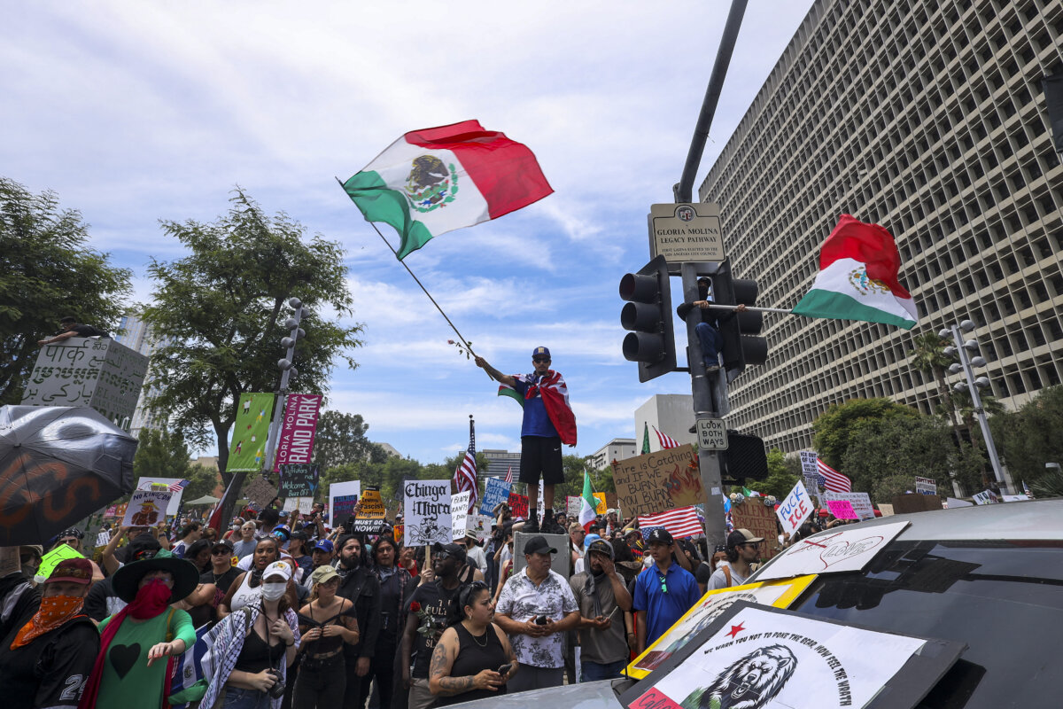 A man waves a Mexican flag during a rally to protest ICE, Trump, and his policies in Los Angeles on June 14, 2025. (Sahab Zaribaf/Middle East Images via AFP via Getty Images)
