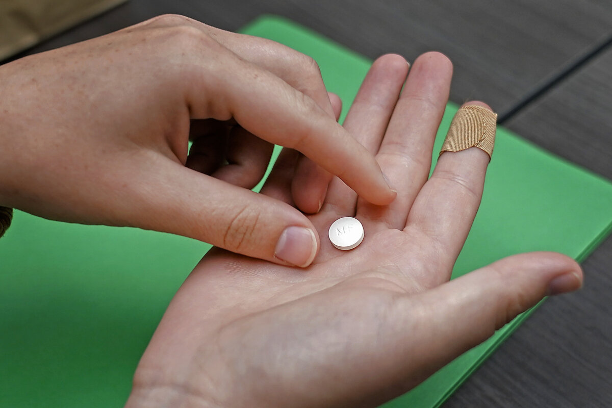 A patient prepares to take a pill for a medication abortion during a visit to a clinic in Kansas City, Kansas, on, Oct. 12, 2022. (Charlie Riedel/AP Photo)