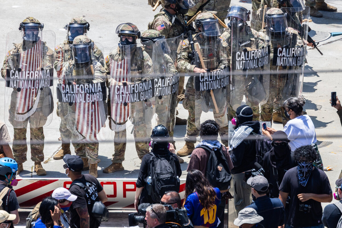 Anti-immigration enforcement protesters confront federal agents and California National Guardsmen in Los Angeles on June 8, 2025. (John Fredricks/The Epoch Times)