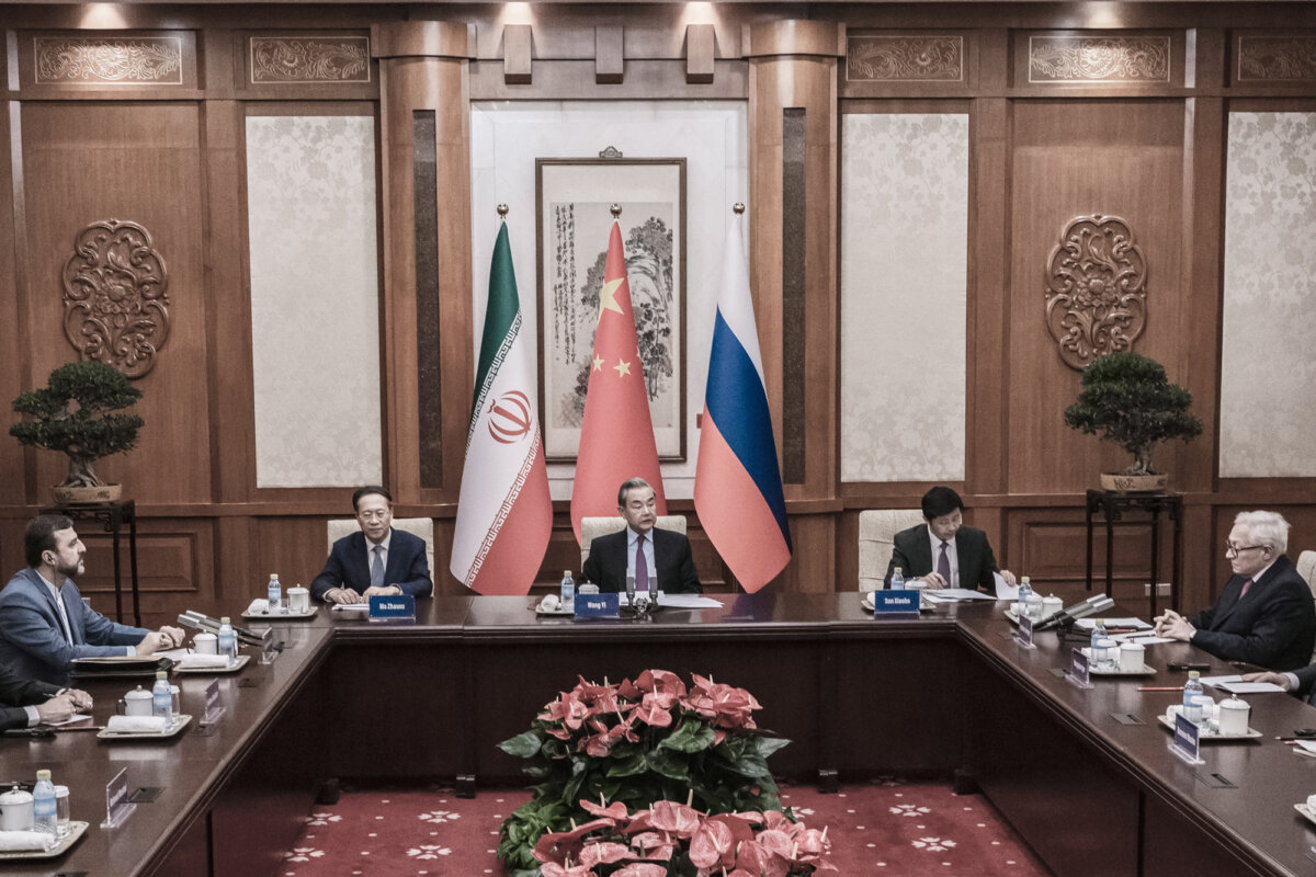 Chinese Foreign Minister Wang Yi (C) sits at the head of a meeting with Russian Deputy Foreign Minister Sergey Ryabkov (Top R) and Iranian Deputy Foreign Minister Kazeem Gharibabadi (Top L) during a meeting regarding the Iranian nuclear issue at Diaoyutai State Guest House in Beijing on March 14, 2025. The Chinese Communist Party (CCP) condemned the recent Israeli and American attacks on Iran’s nuclear and military installations as a violation of Iranian sovereignty. (Stringer/Getty Images)
