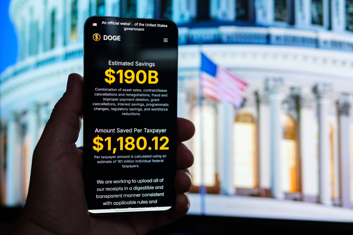 The Department of Government Efficiency (DOGE) website is displayed on a phone, in this photo illustration. (Oleksii Pydsosonnii/The Epoch Times)
