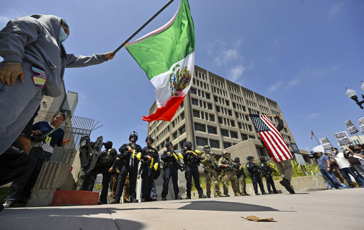 Protesters block the driveway to the federal building as police stand guard in Santa Ana, Calif., on June 9, 2025. (Jeff Gritchen/The Orange County Register via AP)