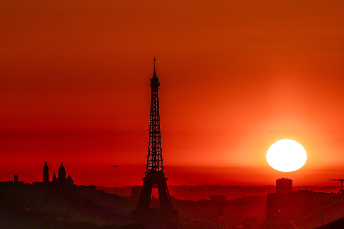 The sun rises by the Eiffel Tower and the Sacre Coeur Basilica on top of the Montmartre hill in Paris on July 1, 2025. (Thibaud Moritz/AFP via Getty Images)