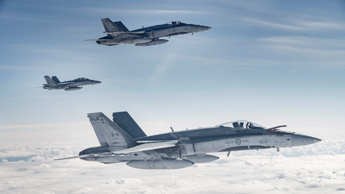 A pair of Royal Canadian Air Force (RCAF) CF-188 Hornets fly with a U.S. Navy EA-18G Growler during Exercise Maple Flag 51 over Alberta on June 15, 2018. (OS Erica Seymour/Canadian Forces/Handout via Reuters)